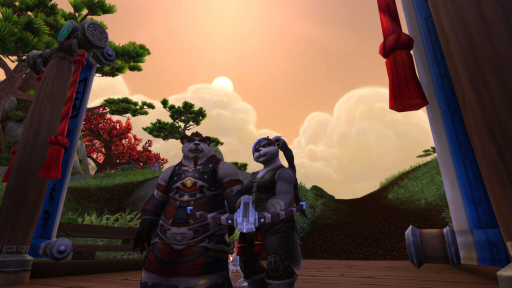 Two pandaren by a red banner