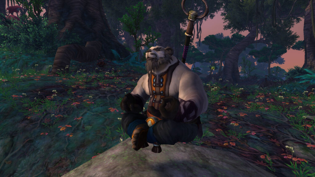 A pandaren sitting quietly in a forest